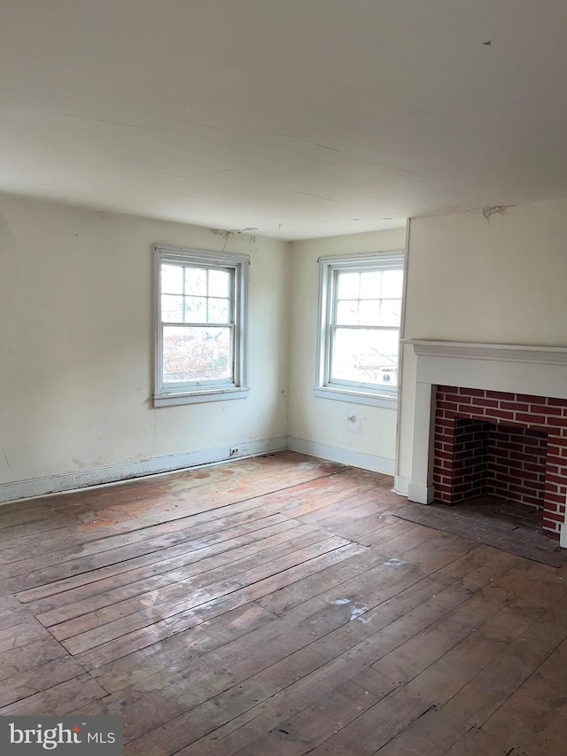 unfurnished living room with hardwood / wood-style flooring, a fireplace, and a wealth of natural light