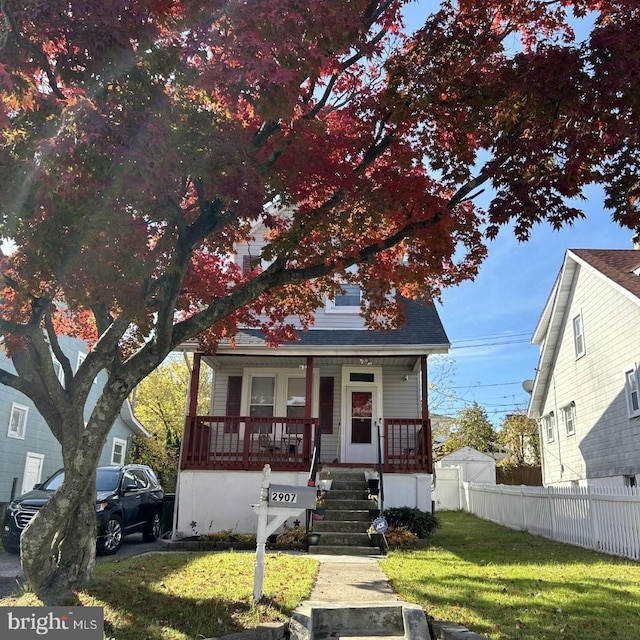 view of front of house featuring covered porch and a front yard