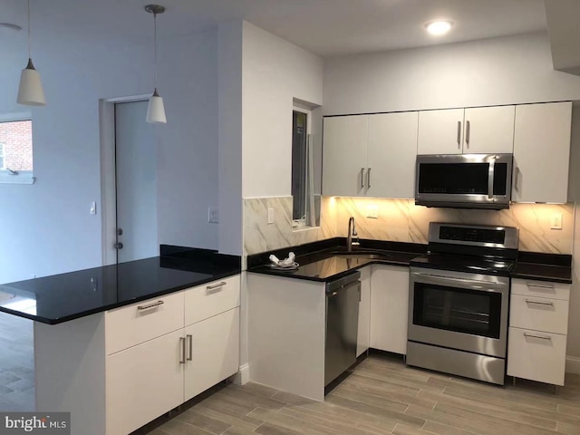 kitchen featuring white cabinetry, sink, pendant lighting, and appliances with stainless steel finishes