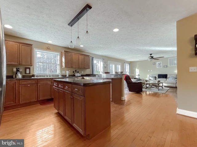 kitchen with a textured ceiling, light hardwood / wood-style flooring, and plenty of natural light