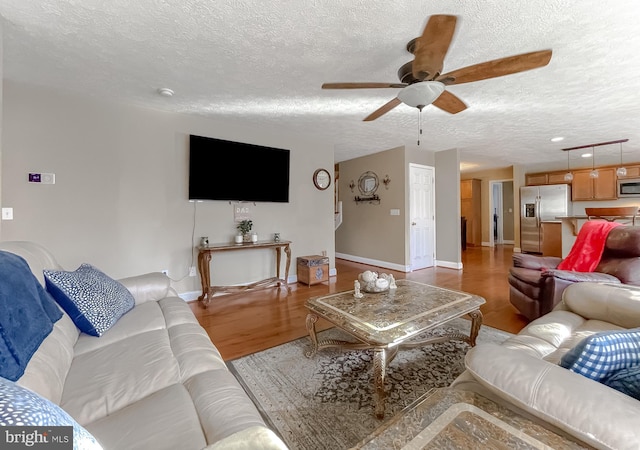 living room featuring a textured ceiling, light hardwood / wood-style flooring, and ceiling fan