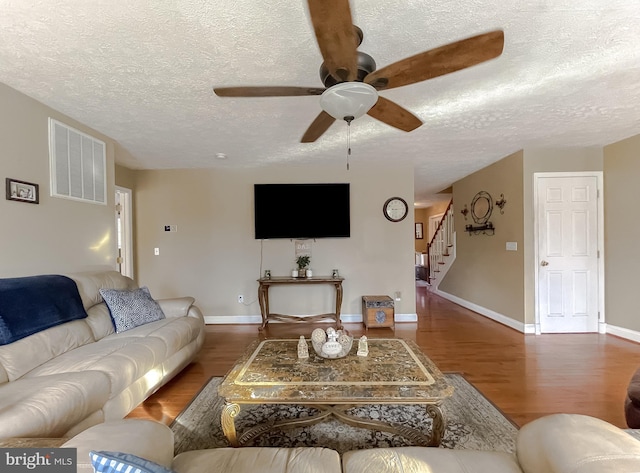 living room featuring a textured ceiling, ceiling fan, and dark hardwood / wood-style floors