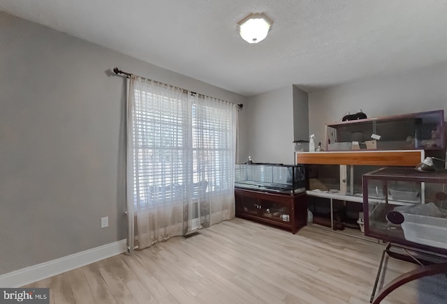 office area with light hardwood / wood-style flooring and a textured ceiling