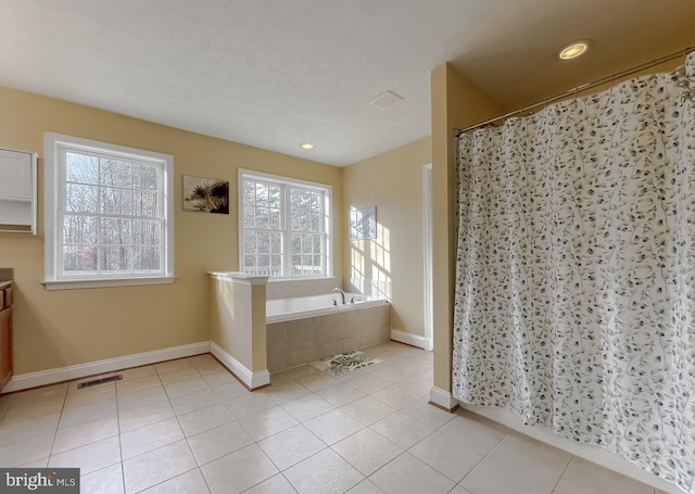 bathroom featuring plus walk in shower, tile patterned flooring, and vanity