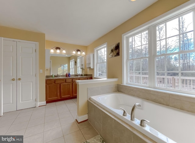 bathroom featuring tile patterned floors, vanity, and tiled tub