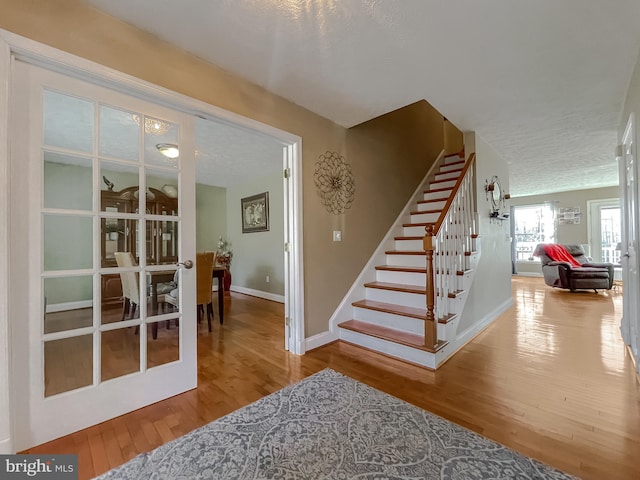 staircase featuring wood-type flooring and a textured ceiling