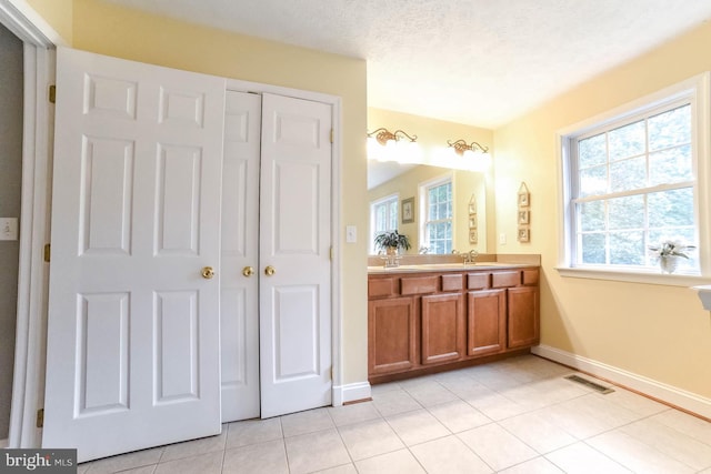 bathroom featuring tile patterned floors, vanity, and a textured ceiling