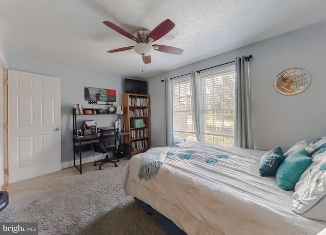 bedroom featuring ceiling fan, carpet, and a textured ceiling