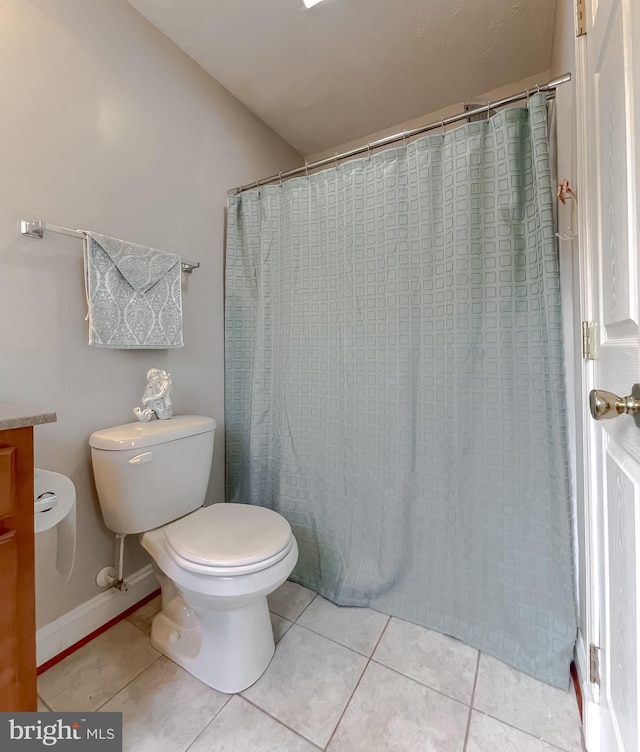 bathroom with tile patterned floors, toilet, and a shower with shower curtain