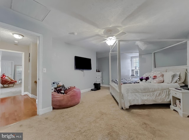 carpeted bedroom featuring ceiling fan and a textured ceiling