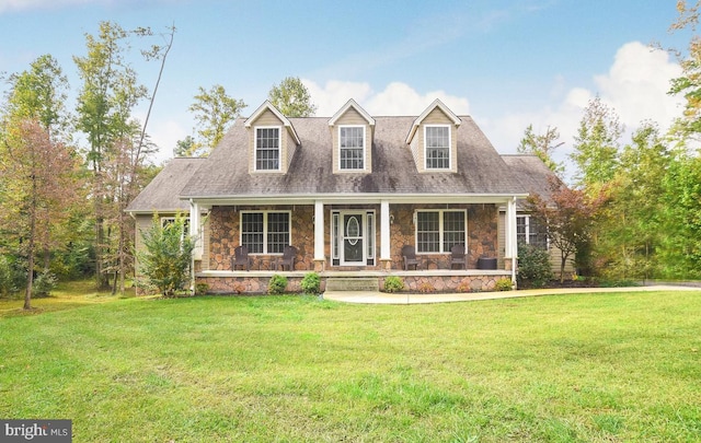 new england style home featuring a porch and a front lawn