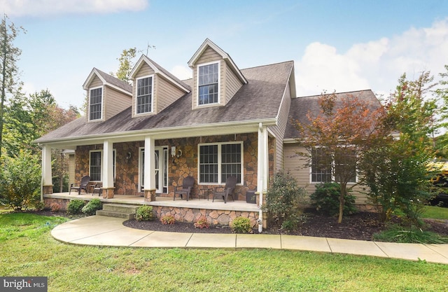 new england style home with covered porch and a front yard