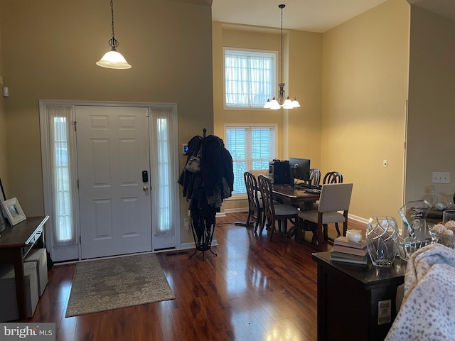 entryway featuring dark hardwood / wood-style flooring, a high ceiling, and a chandelier