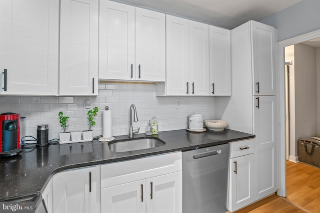 kitchen with sink, white cabinets, stainless steel dishwasher, and light hardwood / wood-style flooring