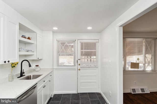 kitchen featuring sink, white cabinets, stainless steel dishwasher, light stone countertops, and a healthy amount of sunlight