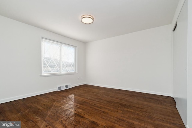 spare room with dark hardwood / wood-style floors