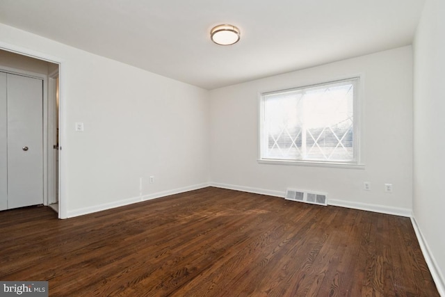 unfurnished room with dark hardwood / wood-style flooring