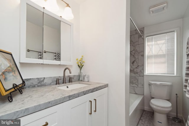 full bathroom with vanity, tiled shower / bath, and toilet