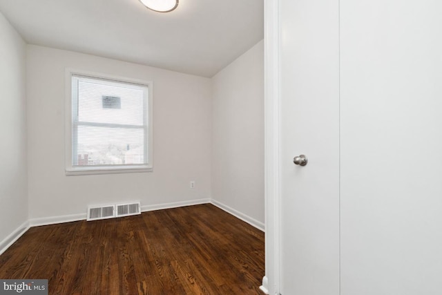 spare room with dark wood-type flooring