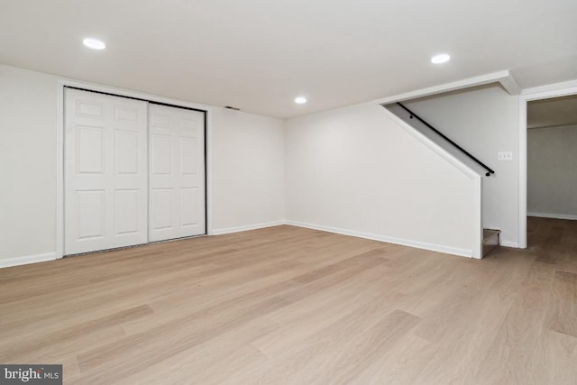 basement with light hardwood / wood-style flooring