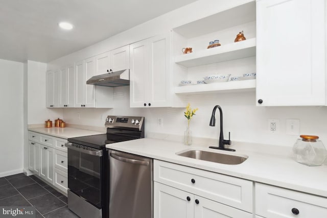 kitchen with sink, dark tile patterned flooring, white cabinets, and appliances with stainless steel finishes