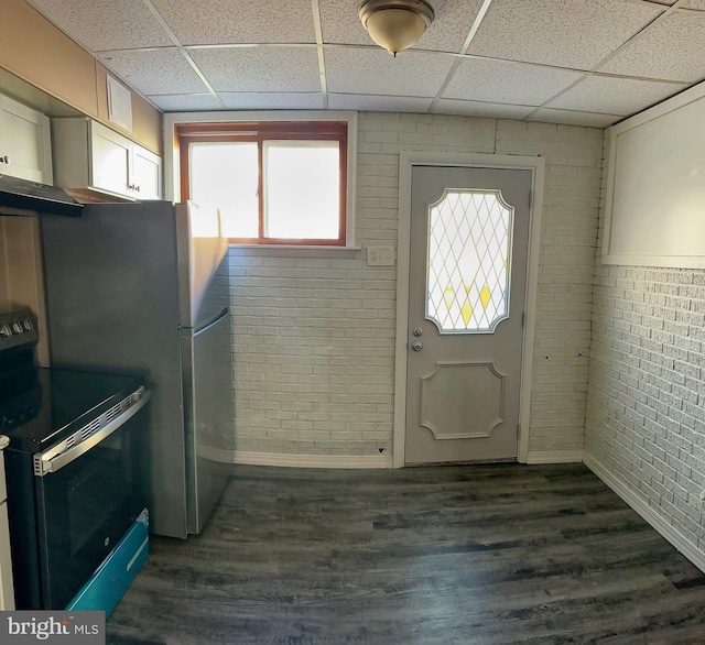 kitchen with dark hardwood / wood-style flooring, stove, a drop ceiling, and brick wall