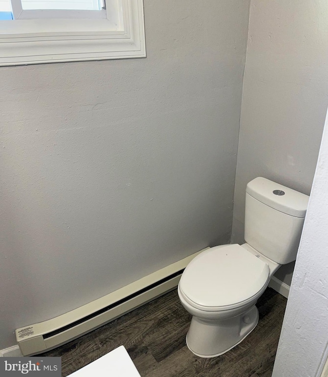 bathroom with baseboard heating, toilet, and hardwood / wood-style flooring