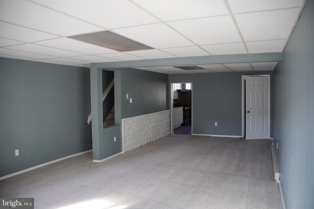 basement featuring a paneled ceiling and carpet floors