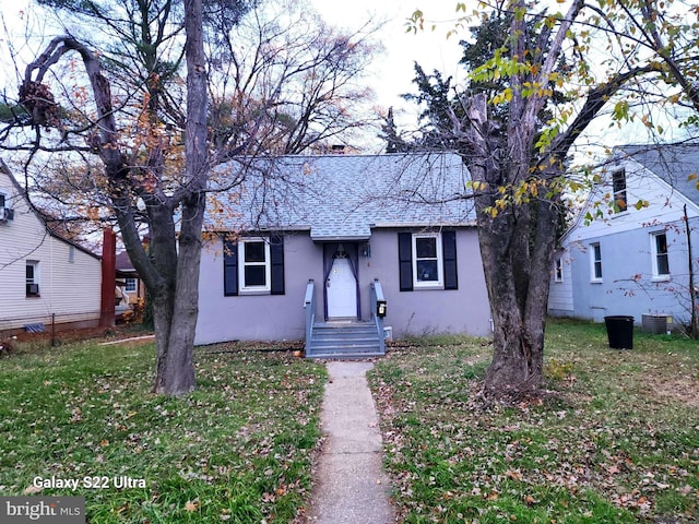 view of front of home featuring central air condition unit and a front yard