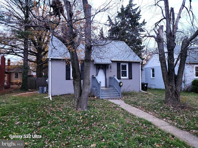 bungalow-style house featuring central AC and a front lawn