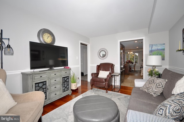 living room with a chandelier and dark hardwood / wood-style floors