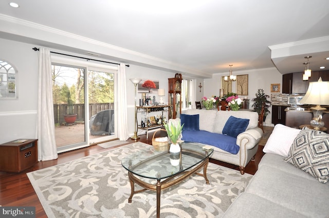 living room with a chandelier, wood-type flooring, and crown molding