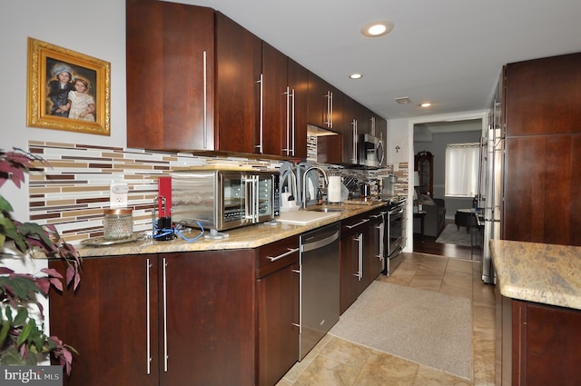 kitchen with backsplash, sink, light tile patterned flooring, and stainless steel appliances