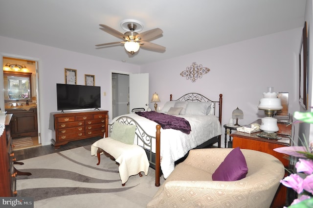 bedroom featuring ensuite bath, ceiling fan, and dark wood-type flooring