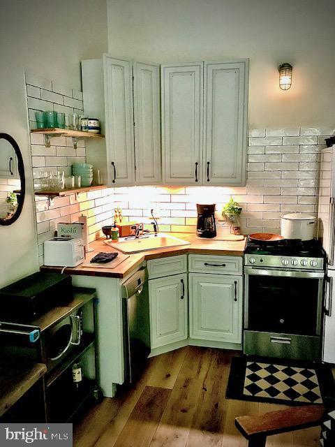 2112 Pine St Unit 1, Philadelphia, PA 19103 - kitchen featuring stainless steel range with gas stovetop, dishwashing machine, tasteful backsplash, and wood finished floors