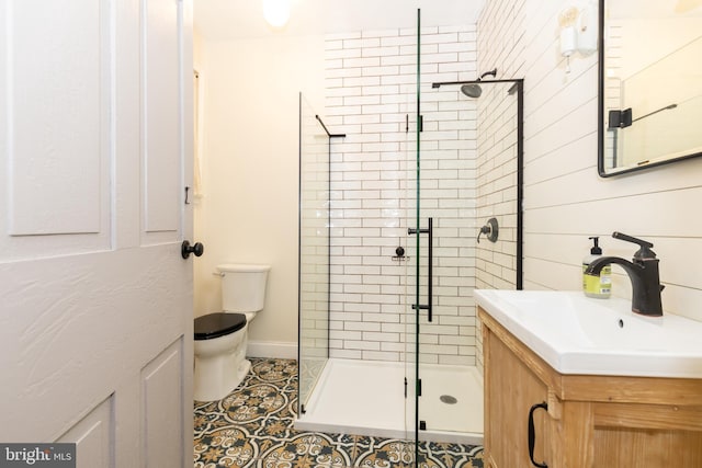 bathroom with tile patterned floors, vanity, toilet, and a shower with door