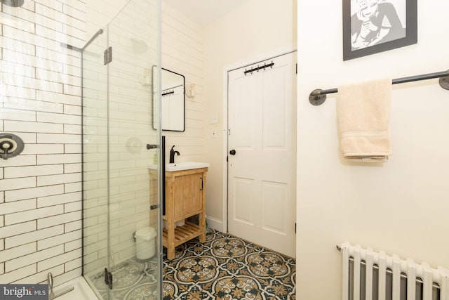 bathroom with vanity, radiator, and a shower with shower door