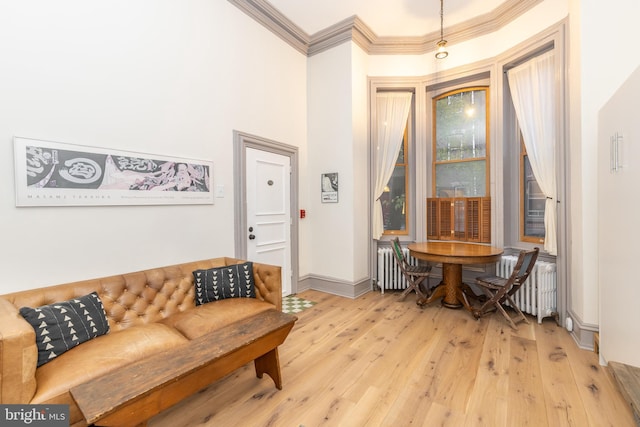 sitting room with light hardwood / wood-style flooring, radiator, and ornamental molding