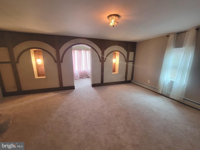 empty room featuring light colored carpet and a baseboard radiator