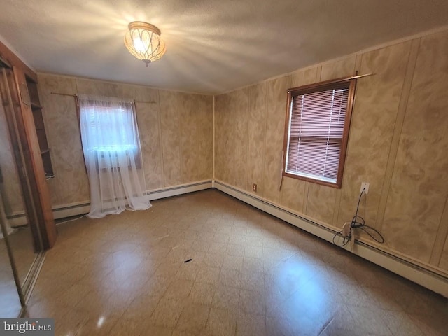 unfurnished room with a baseboard heating unit