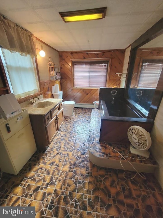 bathroom featuring vanity, tile patterned floors, wooden walls, toilet, and a tub