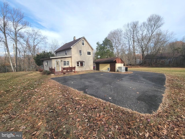 view of side of property featuring an outbuilding, a garage, and a lawn