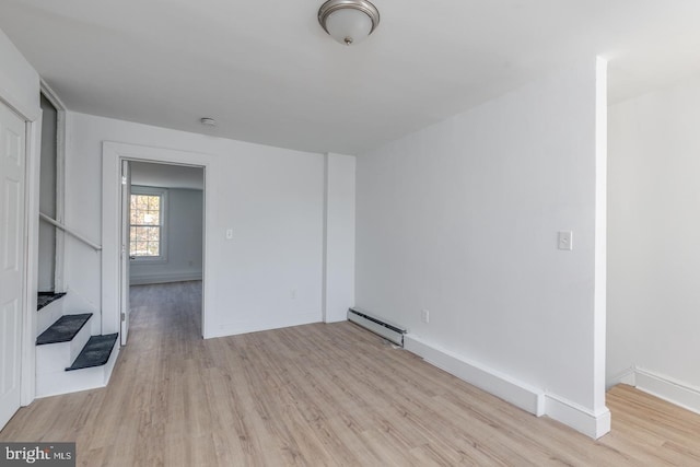 spare room with light wood-type flooring and a baseboard radiator