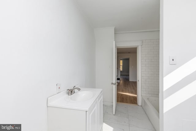 bathroom featuring wood-type flooring, vanity, a tub, and ornamental molding