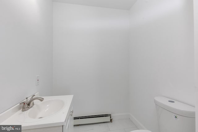 bathroom featuring toilet, vanity, and a baseboard heating unit