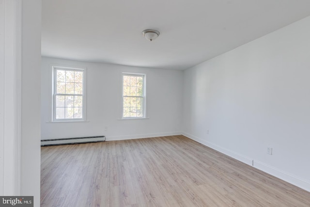 spare room featuring light wood-type flooring and baseboard heating