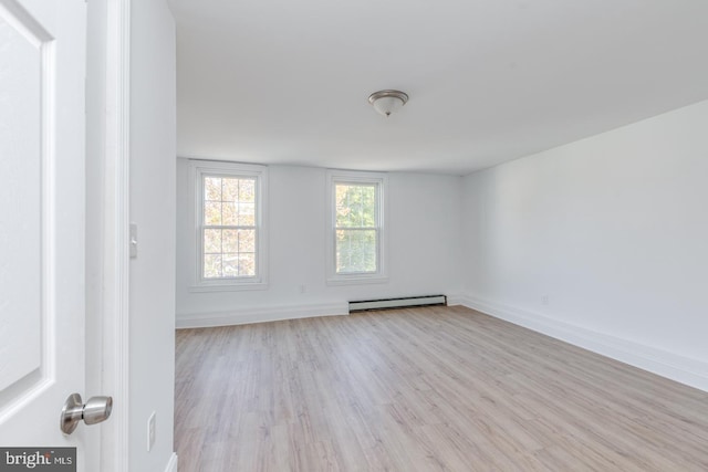 unfurnished room with light hardwood / wood-style floors and a baseboard heating unit