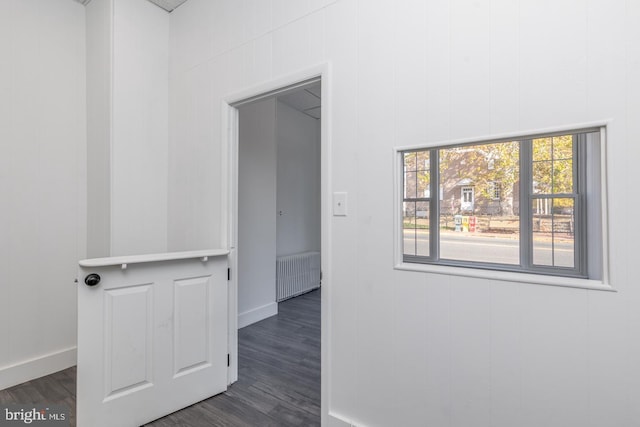 corridor with radiator heating unit and dark wood-type flooring