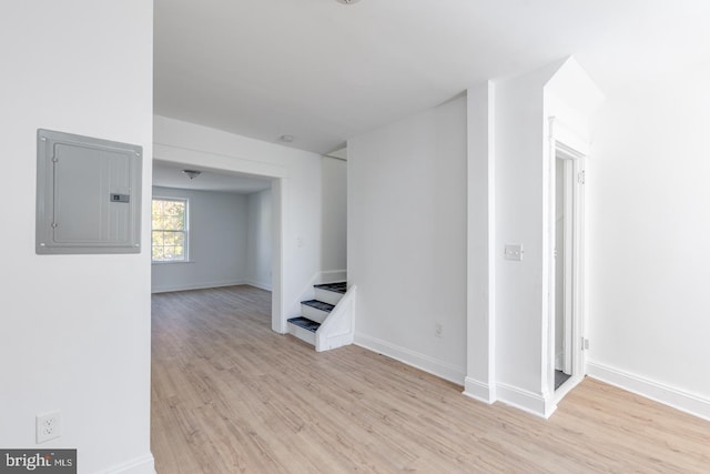 interior space with electric panel and light hardwood / wood-style flooring