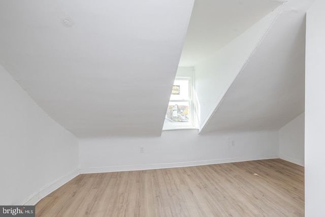 additional living space featuring light hardwood / wood-style flooring and lofted ceiling